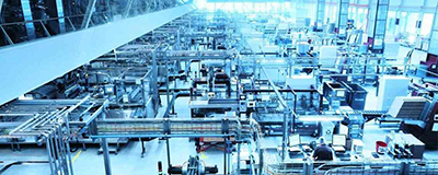A large factory interior with rows of various industrial machines and pipes