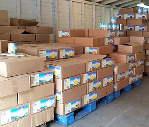 A warehouse filled with cardboard boxes stacked on plastic pallets